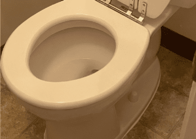 A toilet with the lid up and the seat down.